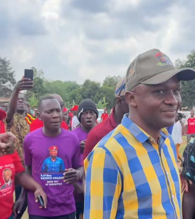 The the Member of Parliament for Kibuku County Hon. Kinobere Hebert, donning on a PLU cape and checked yellow shirt is chased by mourners away from the burial of of former Busiro South MP Hon. Matovu Charles in Kungu Lutale along Nakawuka road on Sunday