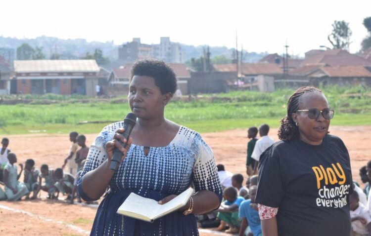 The Makindye Division coordinating centre tutor Ms Allen Abenaitwe addresses pupils and teachers at Kansanga Primary School playgrounds, in Makindye division on Tuesday. Photo/ 360 News Ug